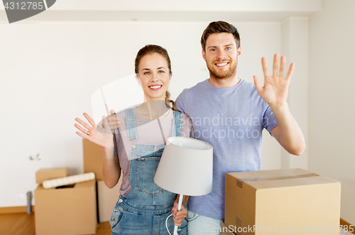 Image of couple with boxes and lamp moving to new home