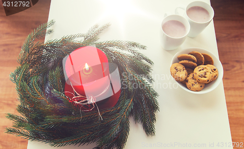 Image of close up of christmas wreath with candle on table