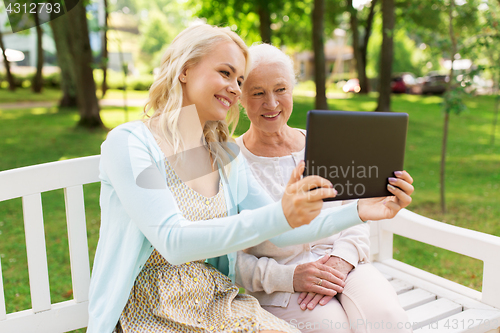 Image of daughter with tablet pc and senior mother at park