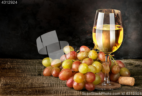 Image of Glass of white wine with grapes