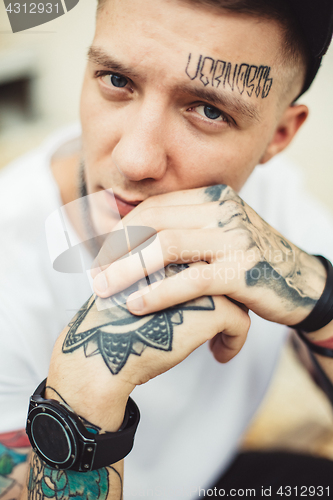 Image of Handsome man in tattoos posing