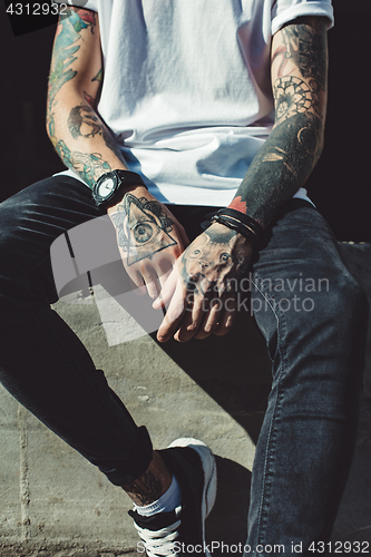 Image of Crop tattooed man outside