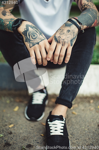 Image of Crop tattooed man outside