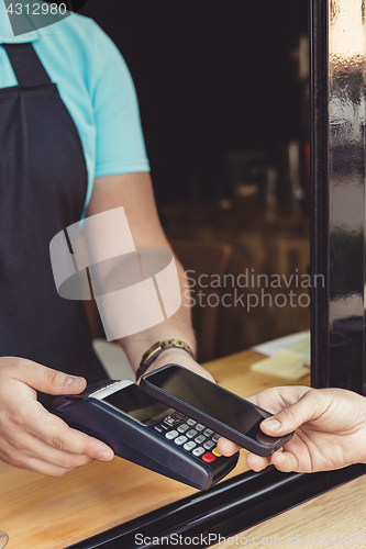 Image of Person paying pay through smartphone using NFC