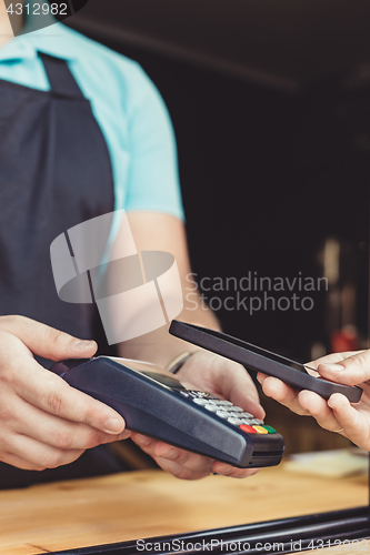 Image of Person paying pay through smartphone using NFC