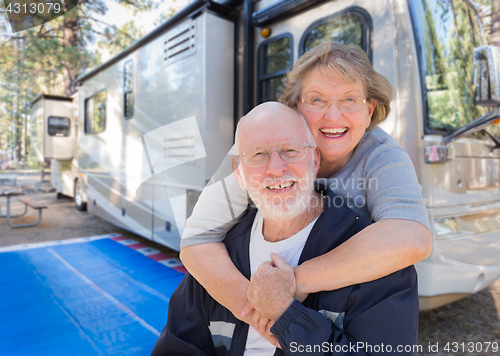 Image of Senior Couple In Front of Their Beautiful RV At The Campground.