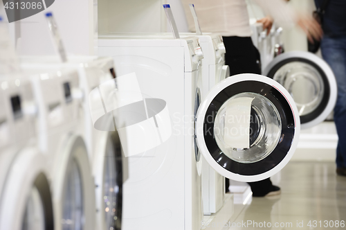 Image of washing machines in appliance store and defocused buyer