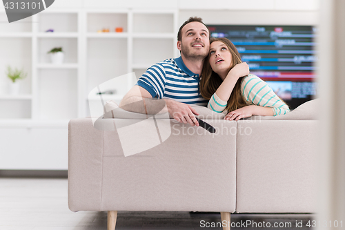 Image of Young couple on the sofa watching television