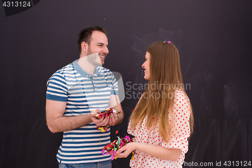 Image of couple blowing confetti in the air isolated over gray