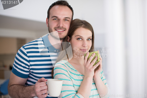 Image of young handsome couple enjoying morning coffee