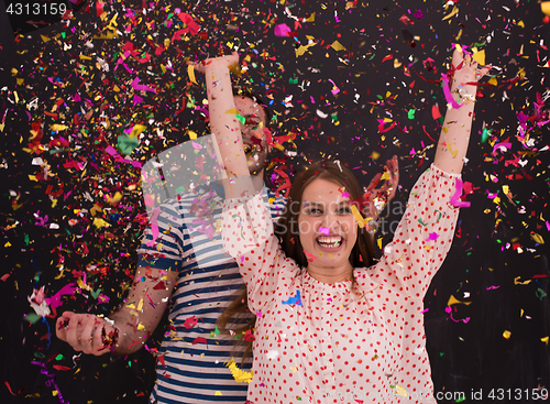 Image of couple blowing confetti in the air isolated over gray