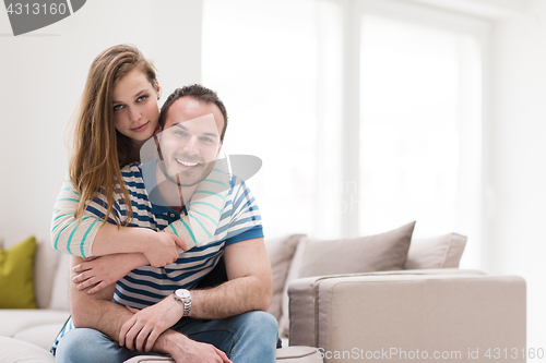 Image of young handsome couple hugging on the sofa