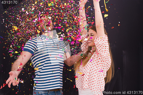 Image of couple blowing confetti in the air isolated over gray