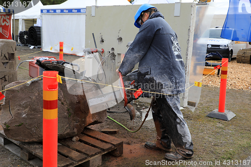 Image of Man Saws Granite Stone with ICS Chainsaw