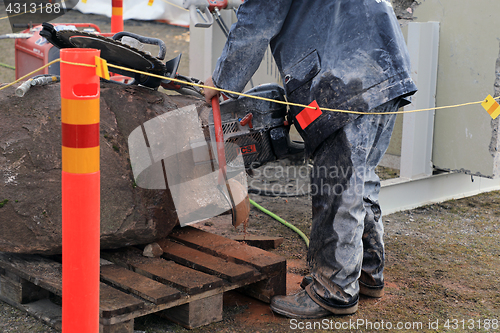 Image of Man Saws Granite with ICS Chainsaw