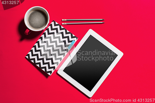 Image of Modern red office desk table with smartphone and cup of coffee.