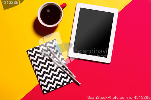 Image of Modern red office desk table with smartphone and cup of coffee.