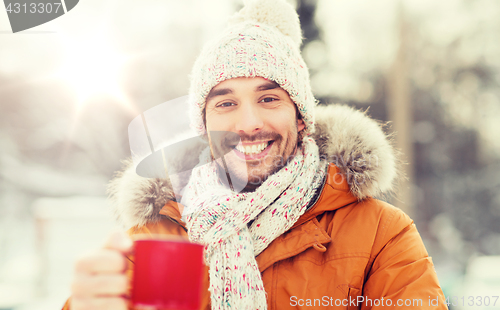 Image of happy man with tea cup outdoors in winter