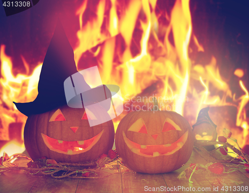 Image of carved halloween pumpkins on table over fire