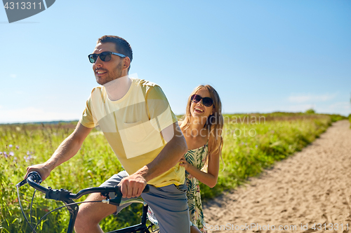 Image of happy couple riding bicycle together in summer