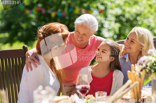 Image of happy family having dinner or summer garden party