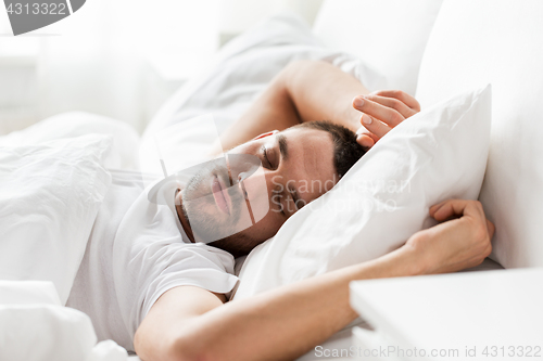 Image of man sleeping in bed at home