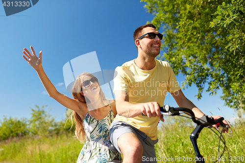 Image of happy couple riding bicycle together in summer