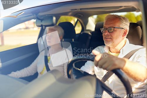 Image of happy senior couple driving in car