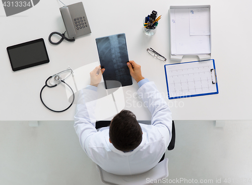 Image of doctor with spine x-ray sitting at table