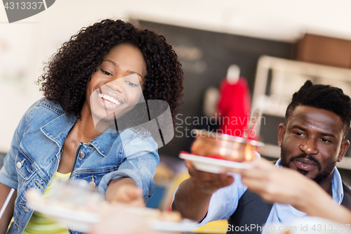 Image of happy african american couple eating at restaurant