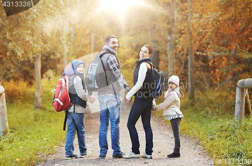 Image of happy family with backpacks hiking walking