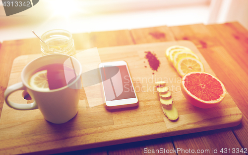 Image of smartphone with cup of lemon tea, honey and ginger