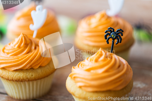 Image of cupcakes with halloween decorations on table