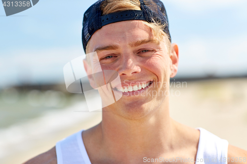 Image of close up of smiling young man on summer beach