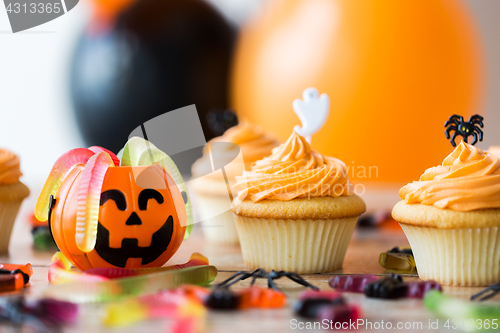 Image of halloween party decorated cupcakes on wooden table
