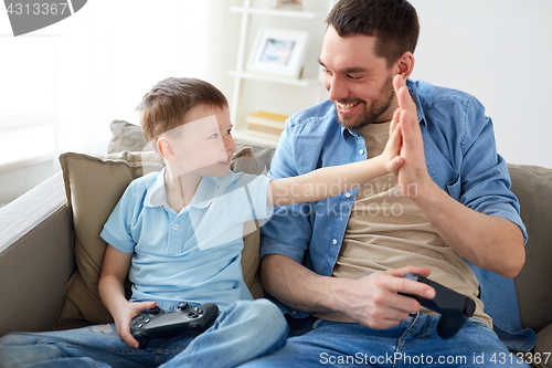 Image of father and son with gamepads doing high five