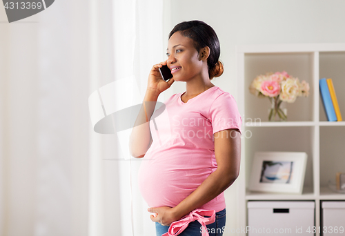 Image of happy pregnant woman calling on smartphone at home