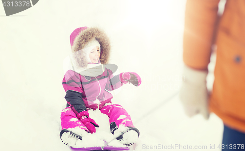 Image of happy little kid on sled outdoors in winter