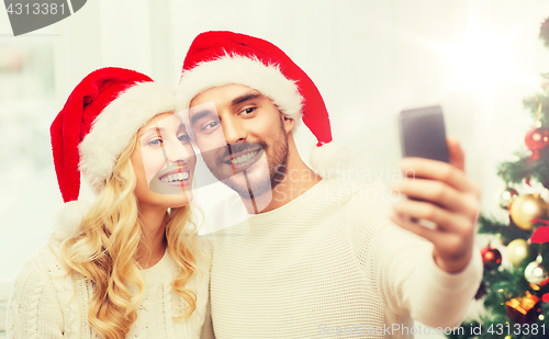 Image of couple taking selfie with smartphone at christmas