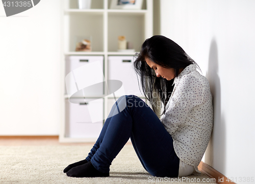 Image of unhappy woman crying on floor at home