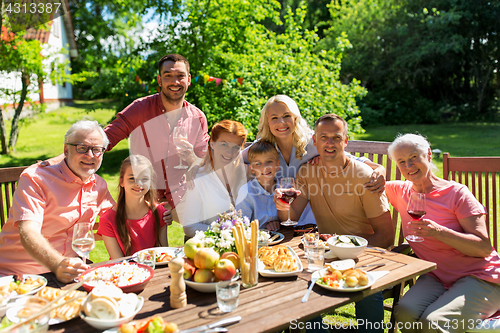 Image of happy family having dinner or summer garden party