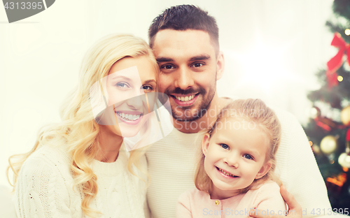 Image of happy family at home with christmas tree