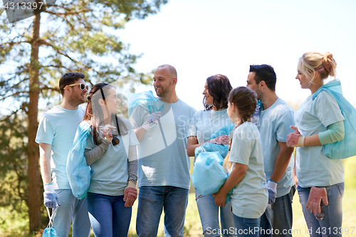 Image of volunteers with garbage bags walking outdoors