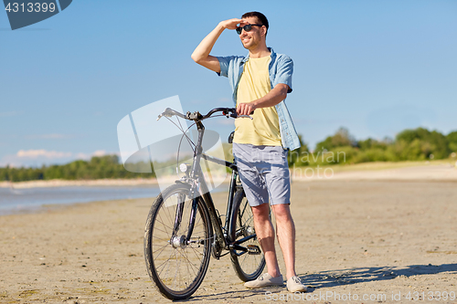 Image of happy man with bicycle on summer beach