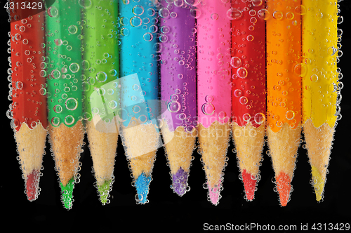 Image of Colorful pencils close-up into water with bubbles