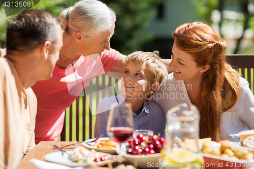 Image of happy family having dinner or summer garden party