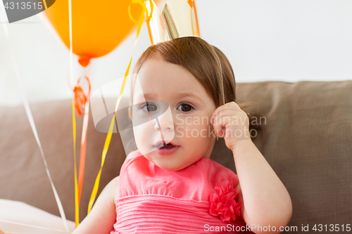 Image of happy baby girl in crown on birthday party at home