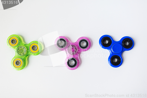 Image of three fidget spinners on white background