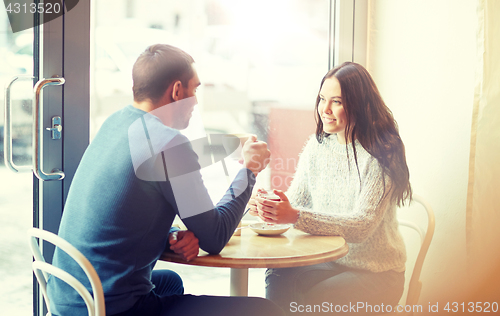 Image of happy couple drinking tea and coffee at cafe