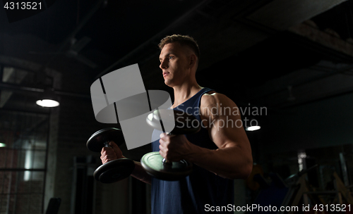 Image of young man with dumbbells exercising in gym